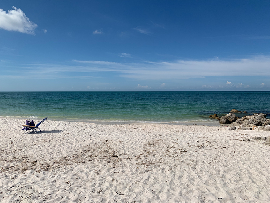 Peaceful view of a beach chair on a Florida beach overlooking the ocean.